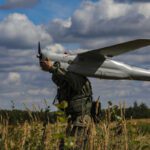 A Russian drone operator carrying the Orlan-10 drone. Photo via Wikimedia.